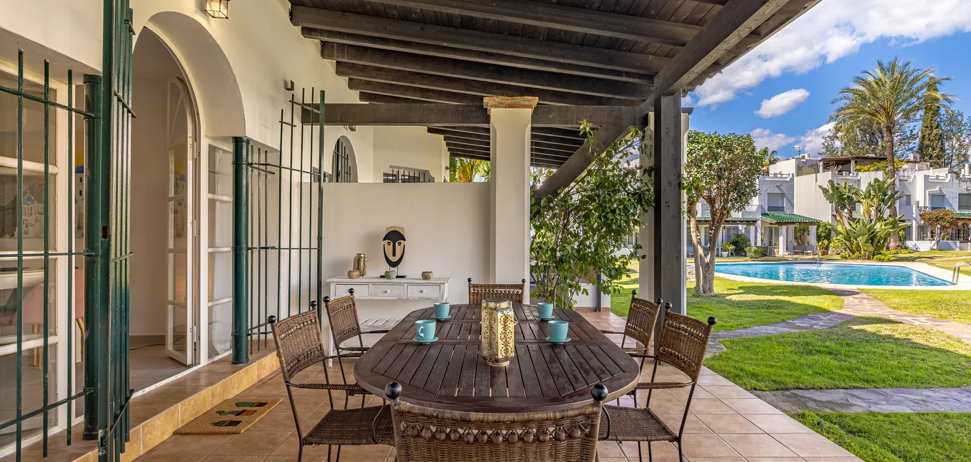 A shaded ground-floor terrace at Sol Europa Golf, table laid for lunch, the garden and pool beyond.