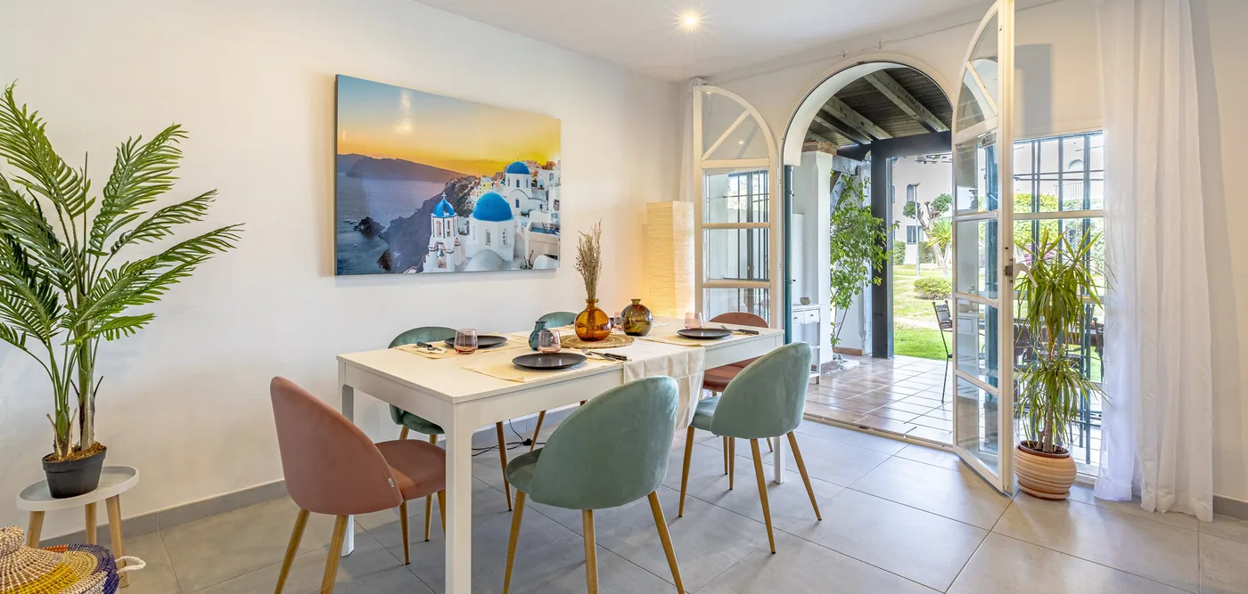 The dining table set for guests, with the doors open onto the garden.